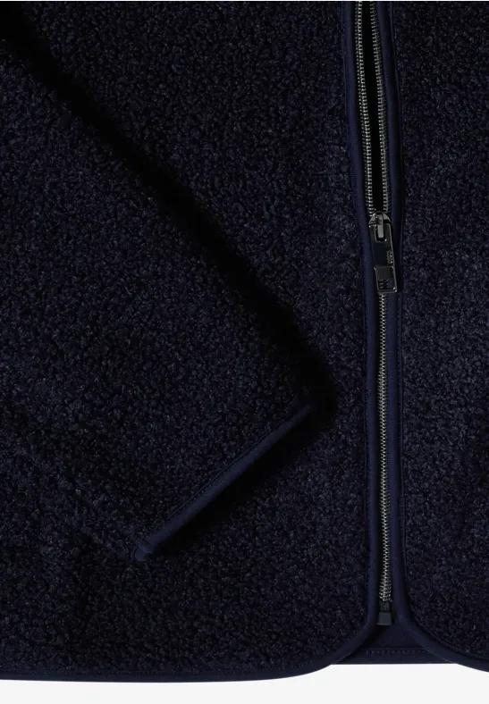 Nahaufnahme einer dunkelblauen Fleecejacke mit Reißverschluss und weichem, flauschigem Stoff.