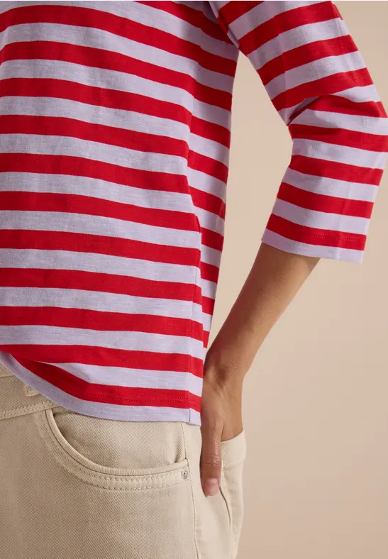 Rumpf mit rot-weiß gestreiftem Shirt und beigen Hosen, Hand in der Tasche