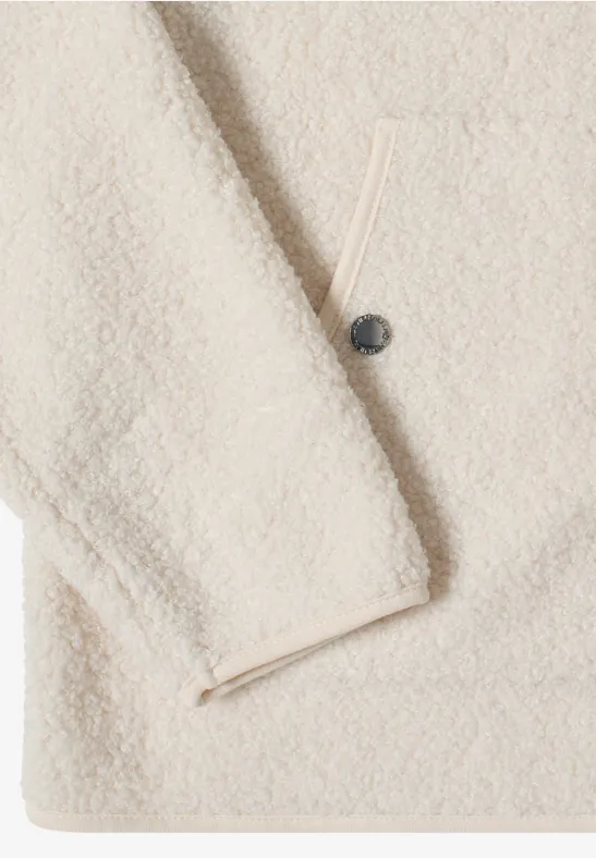 Beige Sherpa-Fleecejacke mit Knopf und Reißverschlusstasche aus weichem, flauschigem Material.