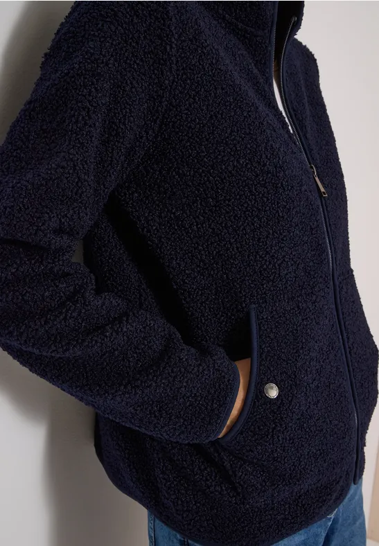 Dunkelblaue Fleecejacke mit Reißverschluss und seitlichen Druckknopf-Taschen, weiches Teddy-Material.