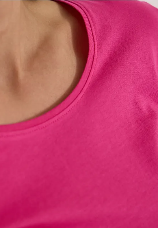 Nahaufnahme eines pinken T-Shirts an Hals und Schulter.