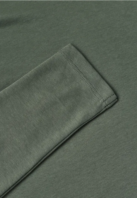 Nahaufnahme eines olivgrünen Langarm-T-Shirts mit sichtbarer Saumnaht.