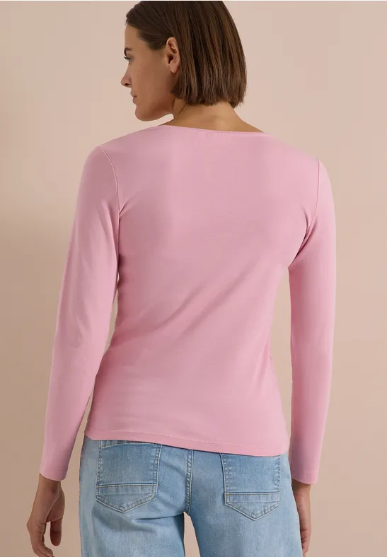 Frau von hinten mit rosa Langarmshirt und blauen Jeans