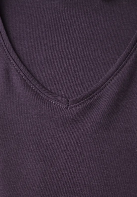 Nahaufnahme eines lila T-Shirts mit V-Ausschnitt aus weichem Stoff.