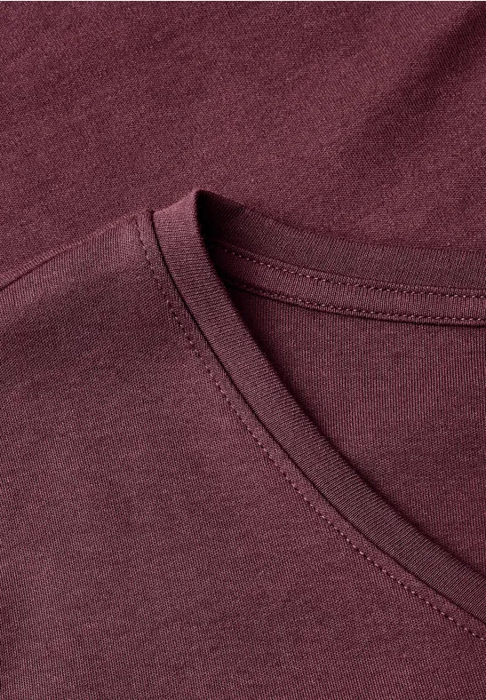 Nahaufnahme eines burgunderroten V-Hals-T-Shirts aus weichem Stoff.