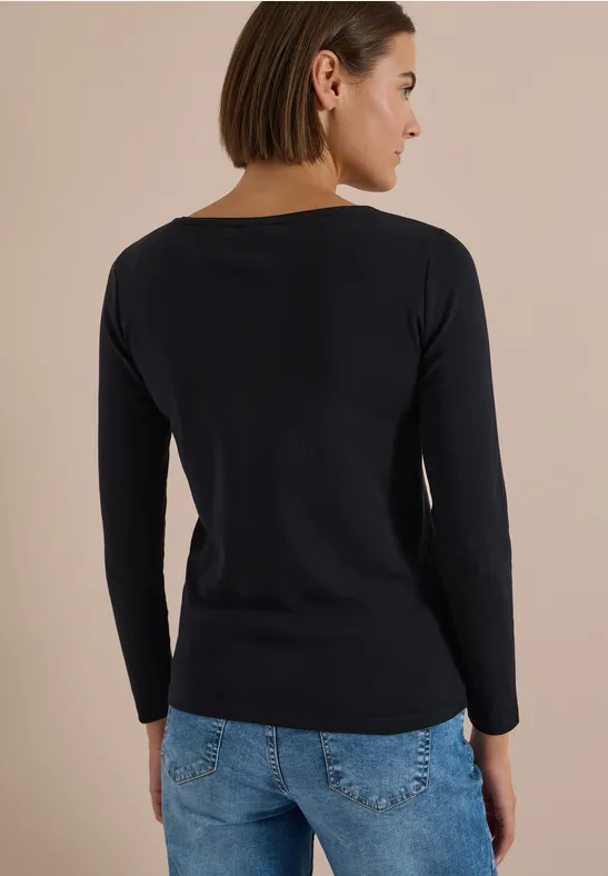 Frau von hinten in schwarzem Langarmshirt und blauen Jeans.