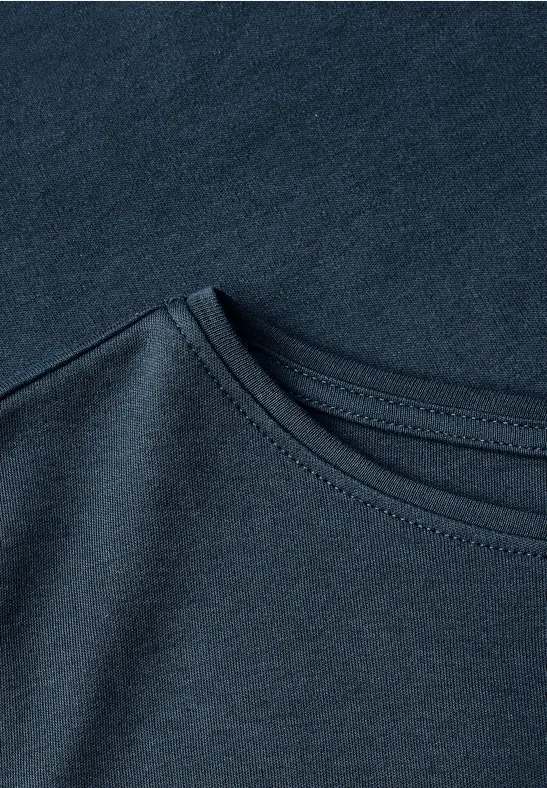 Nahaufnahme eines dunkelblauen Baumwoll-T-Shirts, das den Rundhalsausschnitt und die feine Struktur des Stoffes zeigt.