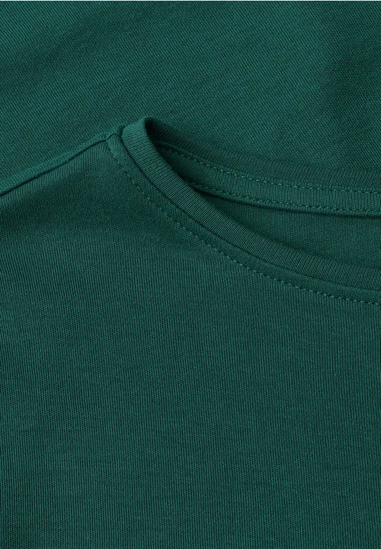 Nahaufnahme eines dunkelgrünen T-Shirt-Ausschnitts aus Baumwollstoff.