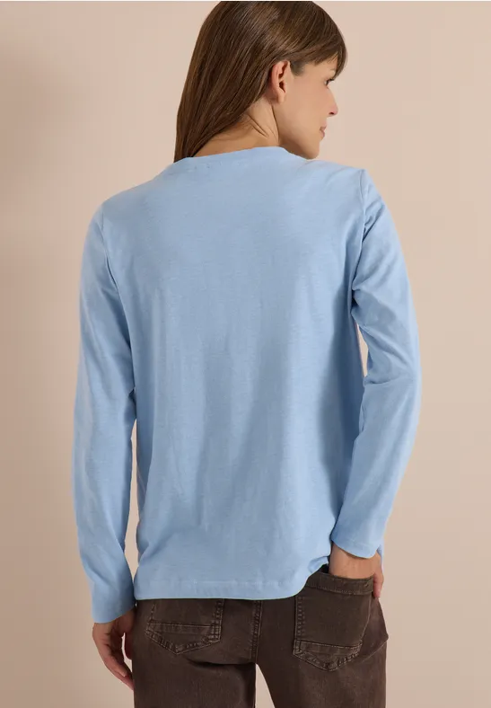 Vue de dos d’une personne portant un t-shirt bleu clair à manches longues.
