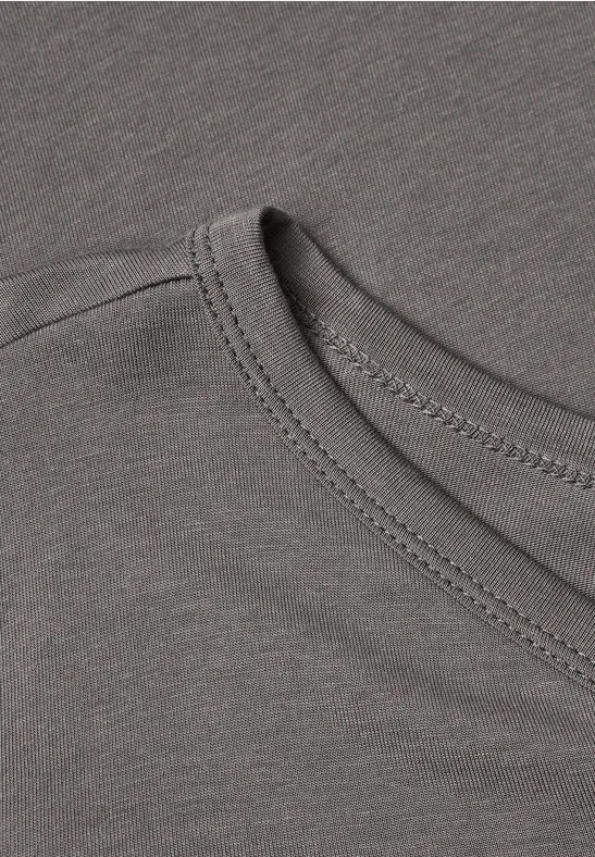 Nahaufnahme eines grauen T-Shirt-Ausschnitts mit sichtbarer Doppelnaht und weicher Jersey-Qualität.