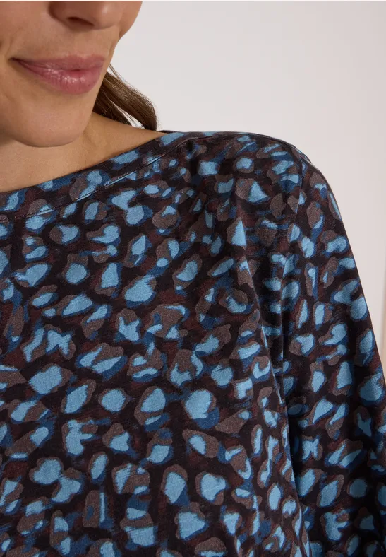 Haut féminin marron à motif léopard abstrait bleu, encolure bateau ample.