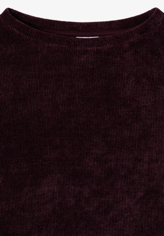 Ein dunkelroter, fein gerippter Pullover aus weichem Material.