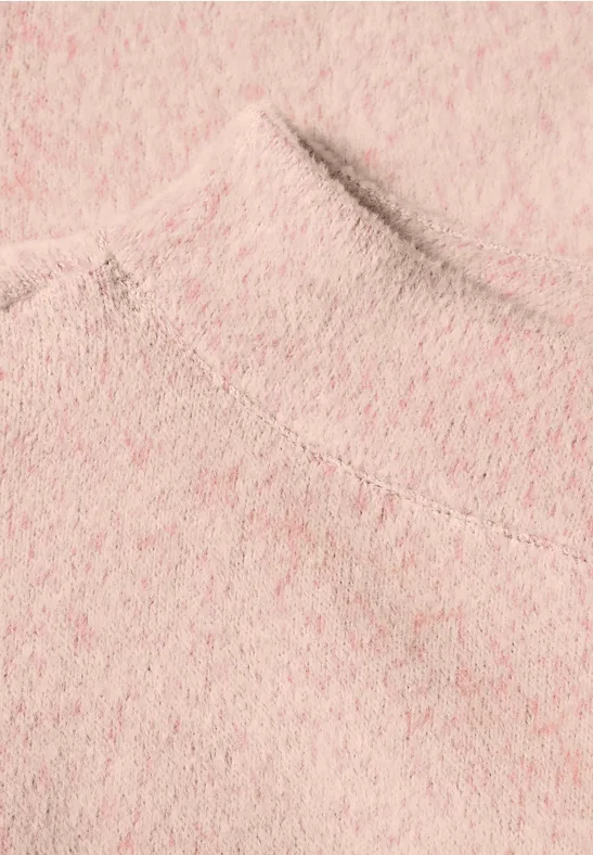 Nahaufnahme eines rosa flauschigen Strickpullovers.