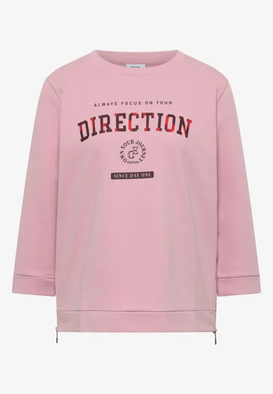 Rosa Sweatshirt mit langen Ärmeln, Kordelzug am Saum und Slogan 'DIRECTION' in bordeauxroter Schrift.