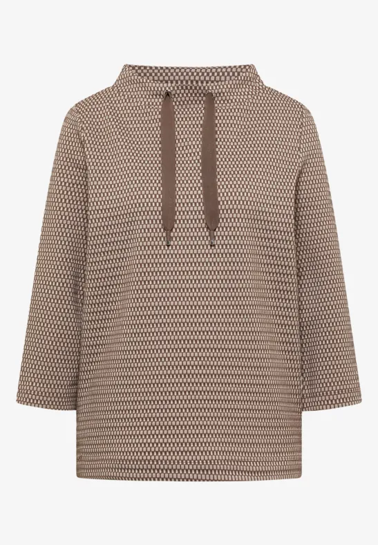 Beiger Kapuzenpullover mit braunem, kleinem geometrischem Muster und Kordelzug.