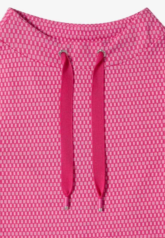 Nahaufnahme eines pinken, feinmaschigen Stoffes mit Kapuzenkordeln.