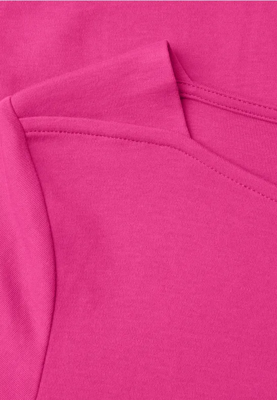 Nahaufnahme eines pinken Stoffstücks mit sichtbaren Nähten und Falten.