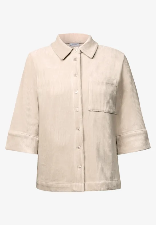 Chemise beige clair à manches 3/4, col classique, poche poitrine et patte de boutonnage épurée.