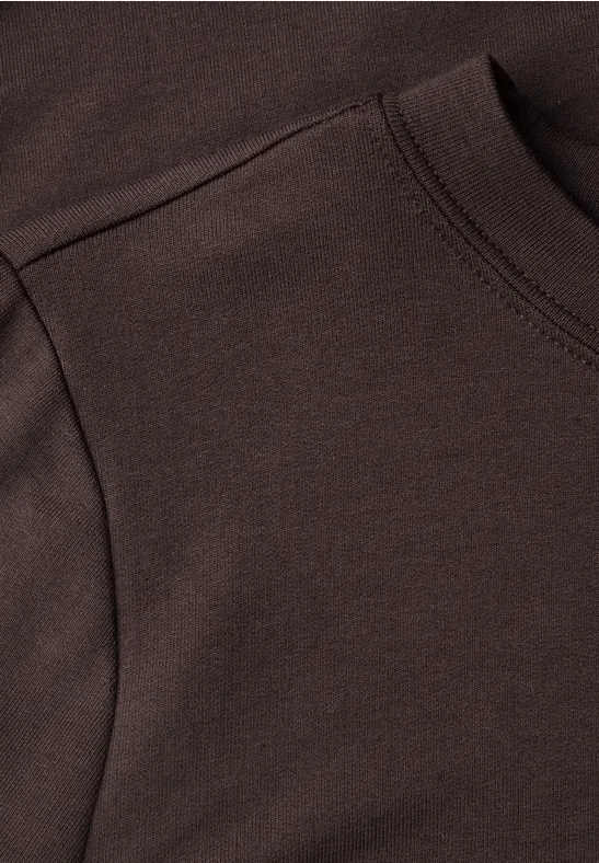 Nahaufnahme eines dunkelbraunen Sweatshirts mit Kängurutasche und sichtbarer Naht