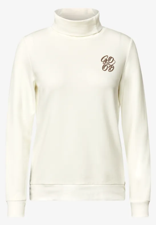 Witte coltrui met lange mouwen en klein monogram op de borst.
