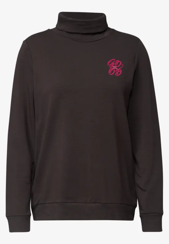 Zwarte coltrui met klein roze logo op de borst.