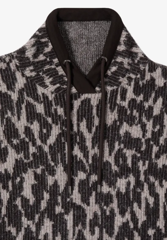 Grobgestrickter Hoodie mit Kapuze, Kordeln und abstraktem schwarz-weißem Muster.