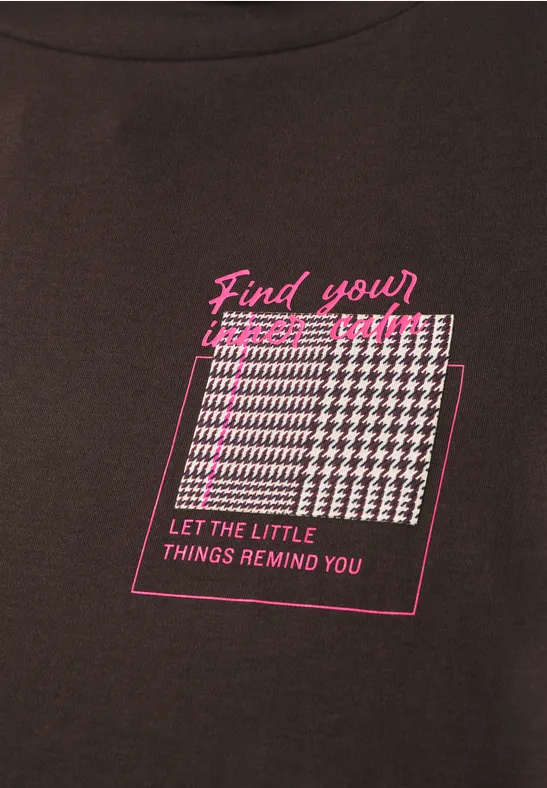 Dunkles Shirt mit pinkem 'Find your'-Schriftzug, weiß-pinkem Hahnentrittmuster und 'Let the little things remind you'.
