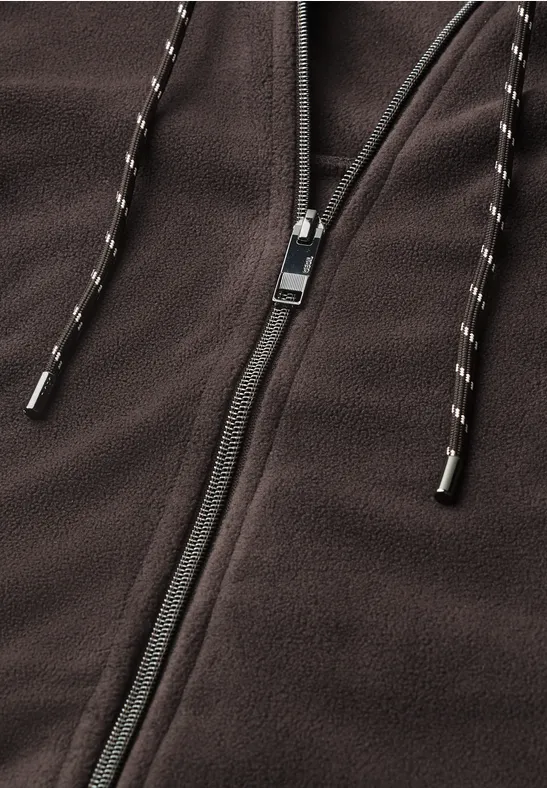 Gros plan d'une veste polaire marron avec fermeture éclair et cordons.