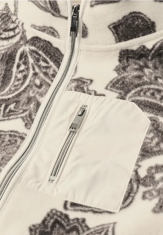 Weißer Fleece mit braunem Barockmuster, Front- und Brusttasche mit silbernen Reißverschlüssen.