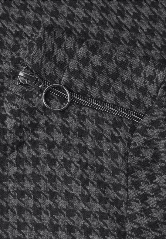 Nahaufnahme eines Reißverschlusses mit rundem Zipper auf schwarz-weißem Hahnentrittmuster.
