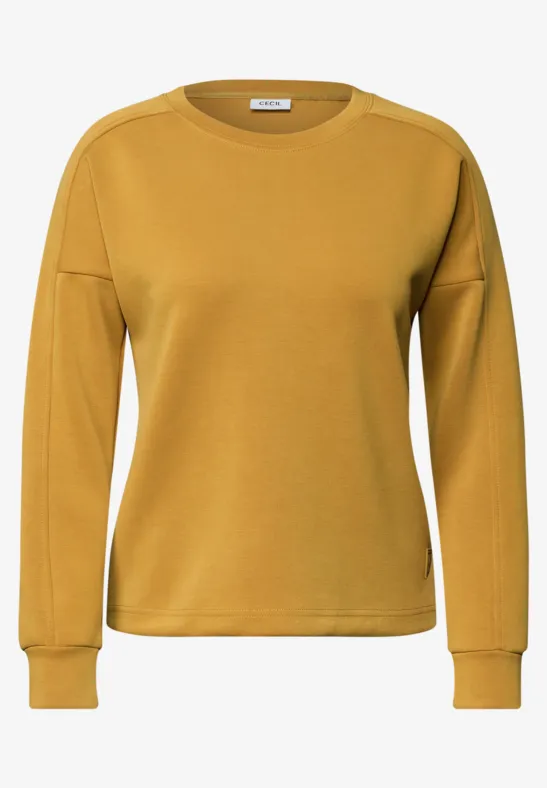 Gelbes Sweatshirt mit Rundhalsausschnitt und langen Ärmeln.
