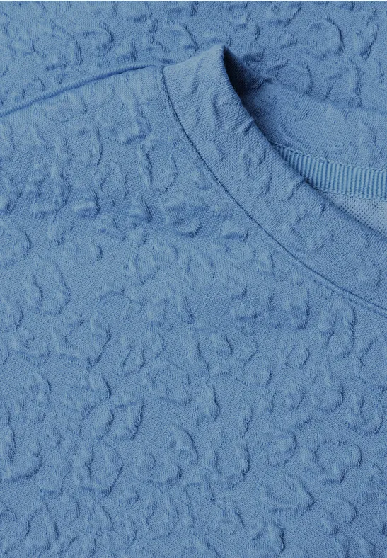 Tissu bleu clair texturé avec motif délicat et encolure ronde