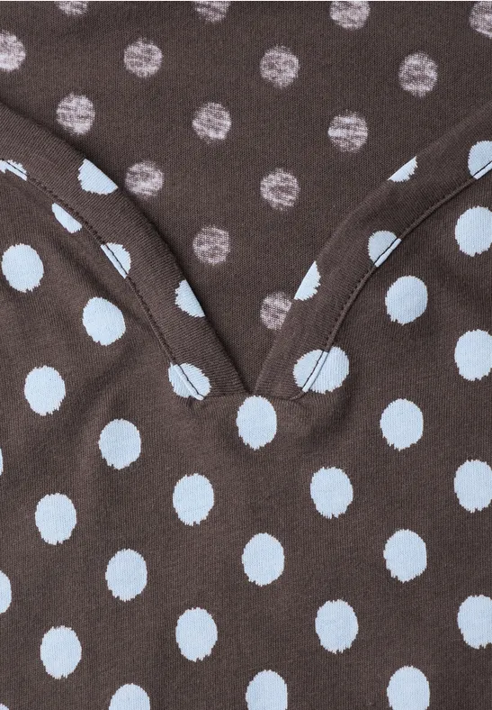 Nahaufnahme eines braunen Stoffes mit kleinen braunen und großen hellblauen Polka-Dots