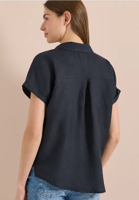 Frau von hinten in dunkelblauem Leinenhemd mit kurzen Ärmeln und Jeans