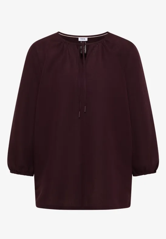 Bordeauxrote Bluse mit 3/4-Ärmeln und Schnürung am Rundhalsausschnitt.