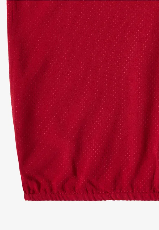 Rotes Mesh-Gewebe mit feiner Netzstruktur und elastischem Saum unten.