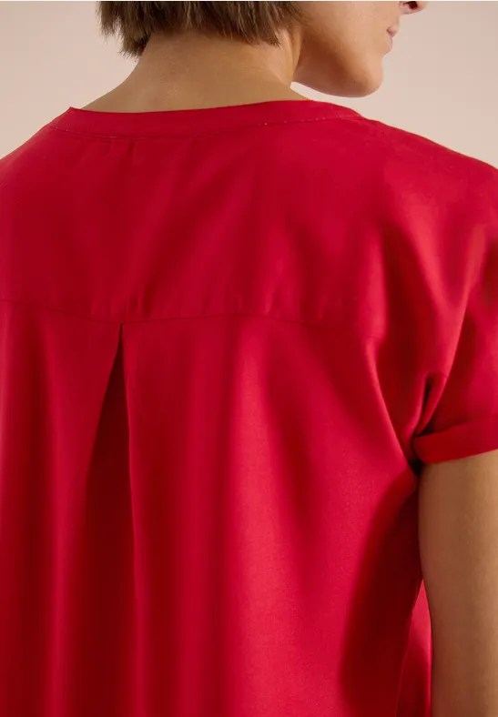 Rückansicht eines roten T-Shirts mit kurzen Ärmeln und Kellerfalte am Rücken.