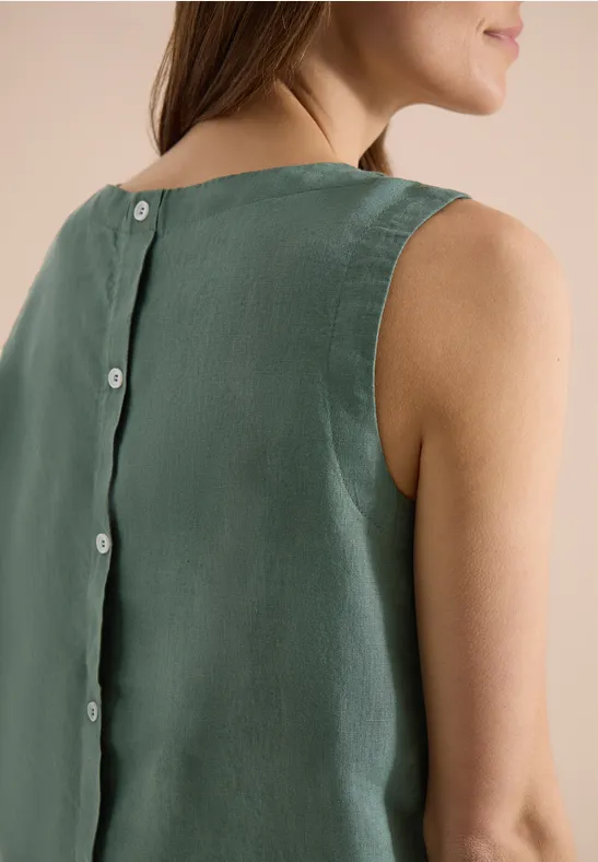 Rückansicht einer Frau in ärmellosem grünen Top mit Knopfleiste am Rücken.