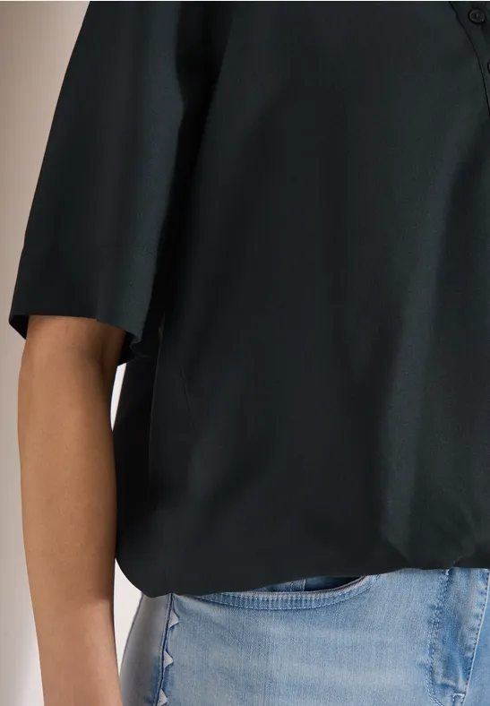 Schwarze Bluse mit 3/4-Ärmeln kombiniert mit hellblauen Jeans