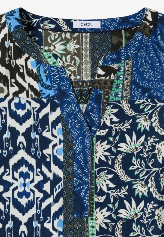 Damenbluse in Blau mit Patchwork aus floralen, geometrischen und Ethno-Mustern.