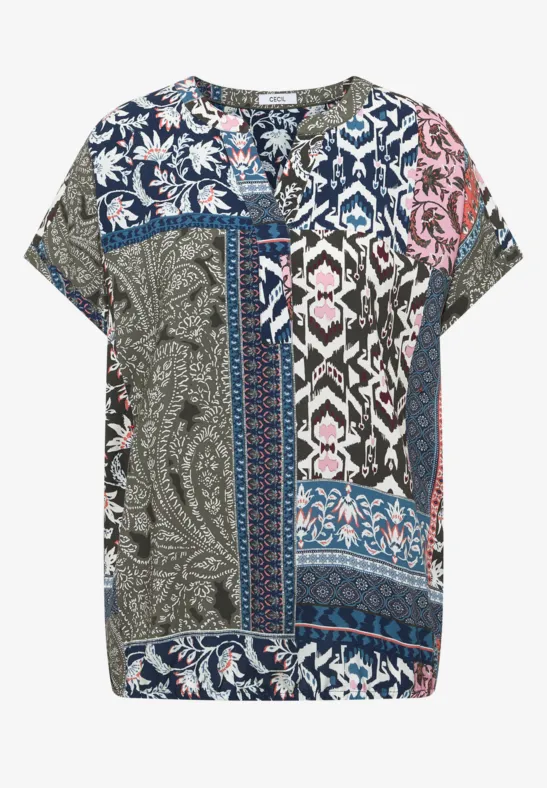 Losse damesblouse met korte mouwen en kleurrijke patchwork van bloemen en grafische patronen.