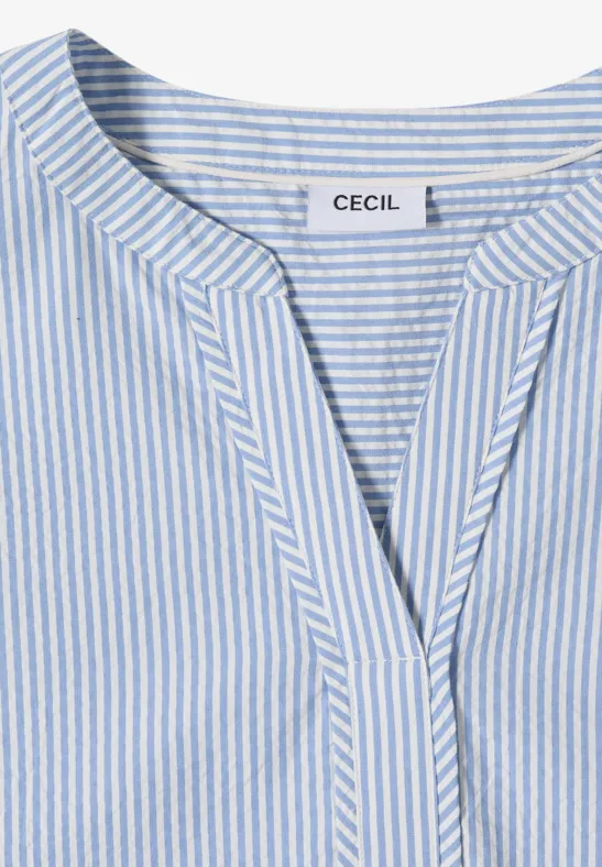 T-shirt féminin bleu clair et blanc à rayures avec col en V et étiquette 'CECIL'.