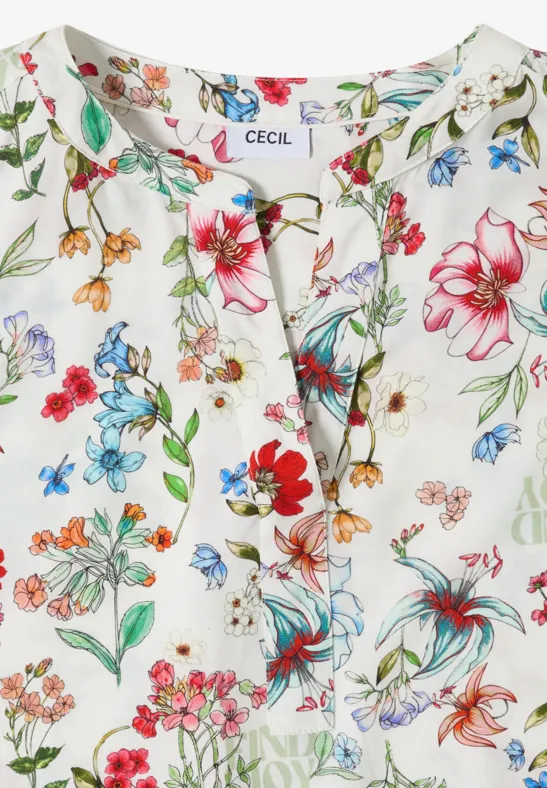 Weiße Bluse mit buntem Blumenmuster und kleinem Schlitz am Ausschnitt.