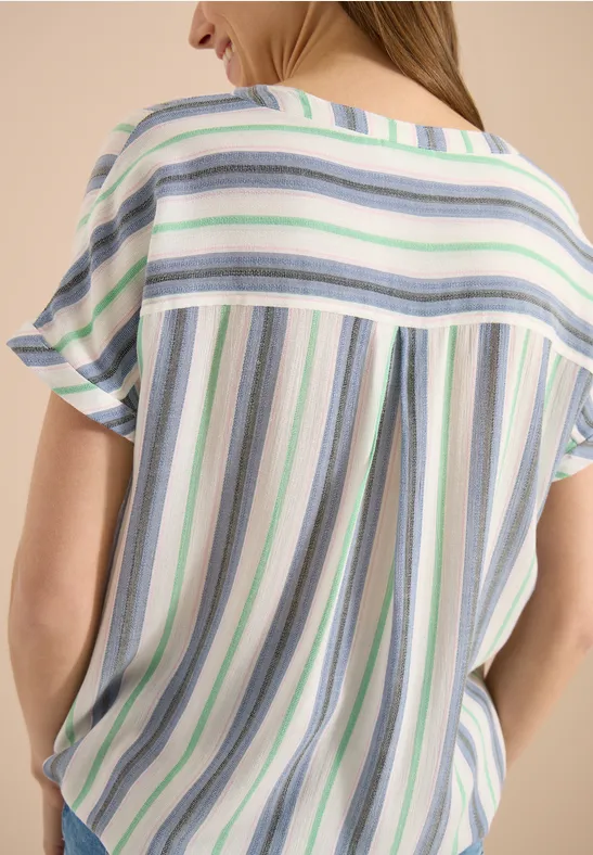Frau von hinten in lockerem Shirt mit pastellfarbenen Streifen.