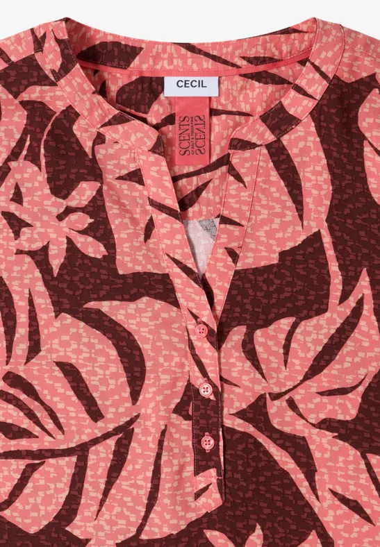 Rote Bluse mit rosenfarbenem, tropisch-inspiriertem Blattmuster.