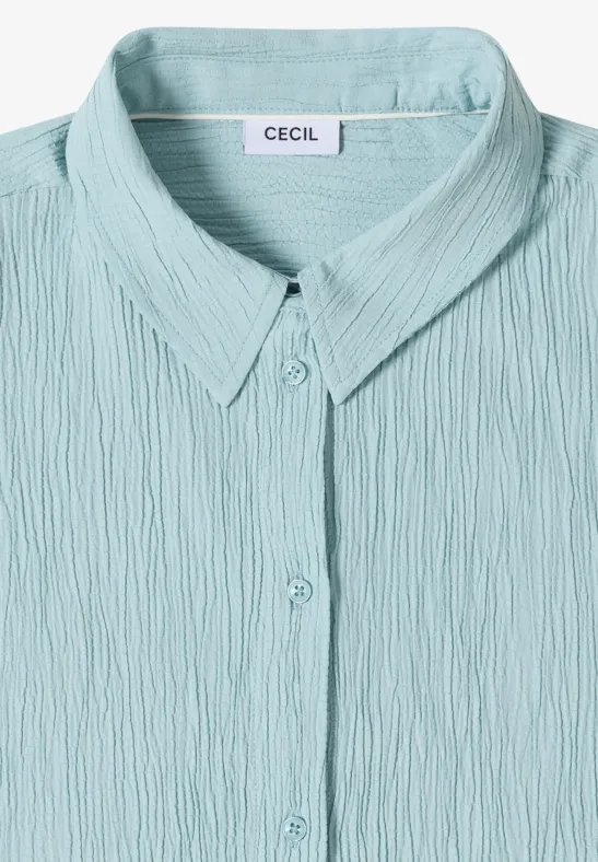eine mintgrüne, texturierte Bluse mit Knopfleiste und Hemdkragen