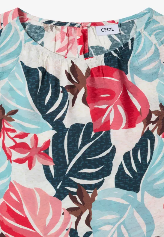 Mouwloze damestop met tropische blad- en bloemenprint in rood, licht- en donkerblauw op witte achtergrond.