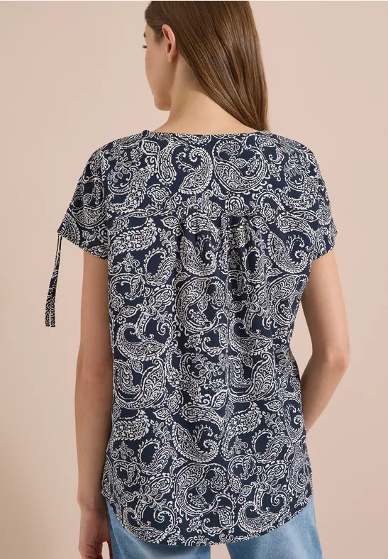 Donkerblauwe damesblouse met wit paisleymotief en korte mouwen met zijlintjes.