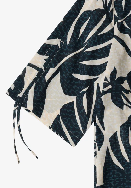 Veste en tissu blanc à motif de feuilles de Monstera bleu foncé, style kimono.