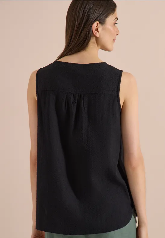Rückenansicht eines schwarzen, ärmellosen Damen-Tops mit Rundhalsausschnitt und leichter Raffung unter der Passe.